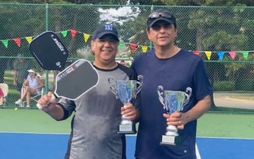 The 2025 Lakeside On Preston Pickleball Cup doubles champions holding their trophies on the court